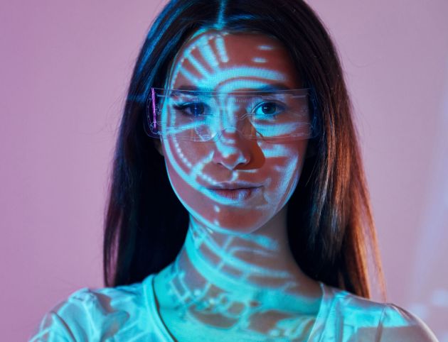 Abstract picture. Beautiful young woman is in projector neon lights in the studio.